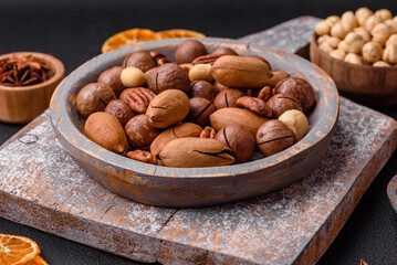 Fototapeta na wymiar Mix of roasted macadamia nuts, cashews, pecans, almonds, raisins and dry berries