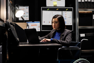 Business invoicing paraplegic management executive asian woman in wheelchair imputing accountancy...