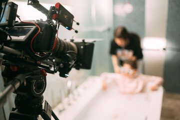 Fototapeta premium Professional cinema and video camera on the set. Shooting shift, lighting fixtures, shooting equipment and the team.