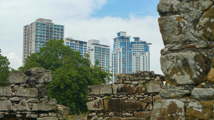 Modern multi-storey buildings rising above old ruins of historical Panama Viejo - obrazy, fototapety, plakaty