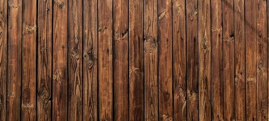 Wall of dark wooden planks in the background of a rural house. wood texture