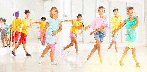 Children studying modern style dances in dance class indoors