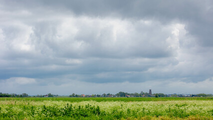 Spring countryside landscape with flat and low land under cloudy clouds, Typical Dutch polder and...