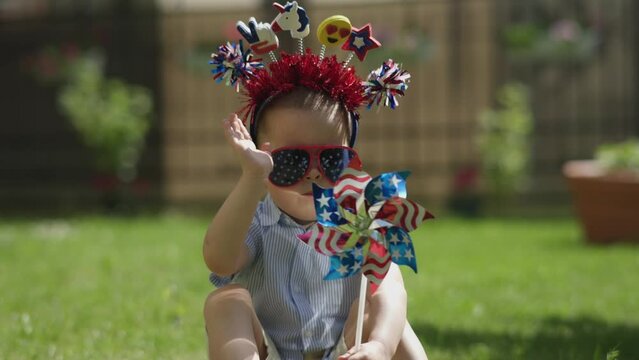 Happy Independence Day USA Holiday Of 4th July Concept Little Boy Kid Red White Blue Funny Mask Playing With Spinning Will Outdoors Green Grass Warm Sunny Day. Celebration American Fourth Of July 