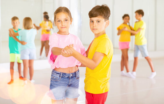 Portrait of active children enjoying of partner dance in class