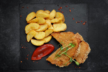 sliced schnitzel with crispy fried potatoes and tangy ketchup