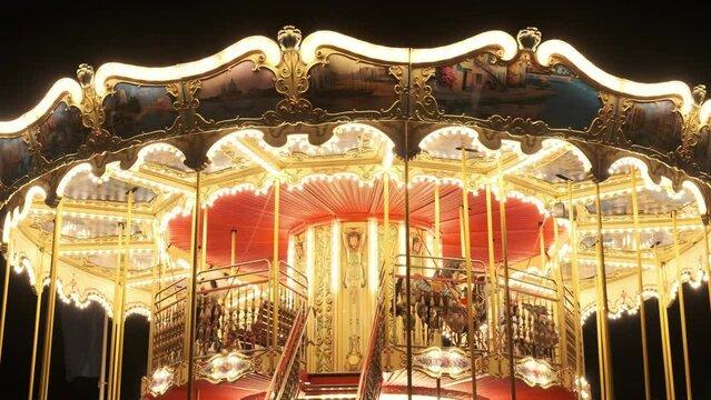 Illuminated retro carousel in amusement park at night
