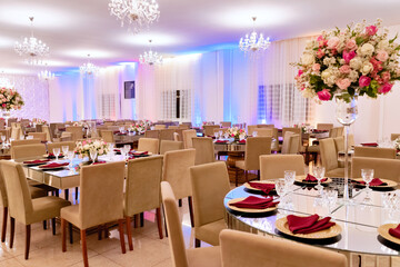 a table with a glass top, sousplat and pink napkins with an arrangement in the center