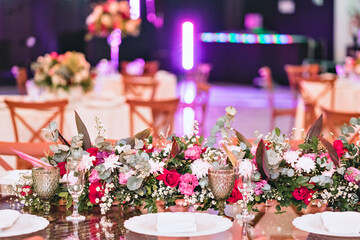 a hall decorated with vases with pink and red flowers