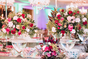 a hall decorated with vases with pink and red flowers