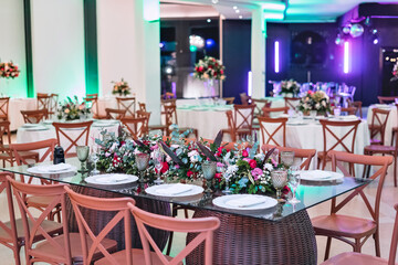 a rectangular glass table with china plates and a flower decoration in the middle