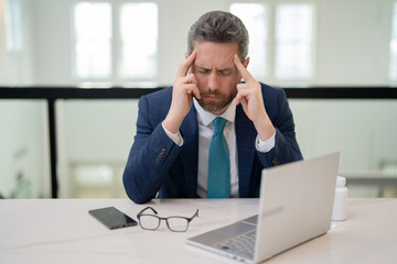 Overworked burnout man feeling migraine head strain. Tired bored business man has office syndrome. Exhausted man with migraine or headache. Office worker, manager or freelancer having a headache.