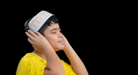 Young asian muslim boy in yellow shirt isolated on black background with clipping paths.