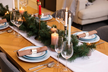 Festive table setting and beautiful Christmas decor in room. Interior design