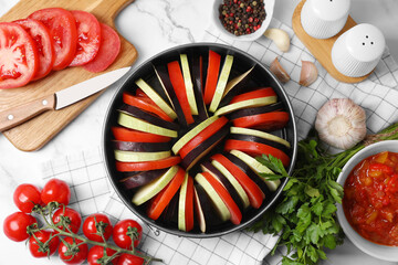 Fototapeta na wymiar Dressing for delicious ratatouille and different vegetables on white marble table, flat lay