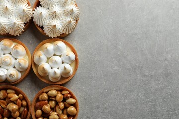 Many different tartlets on light grey table, flat lay with space for text. Tasty dessert