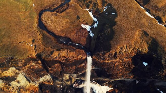 Drone shot of foss a sidu waterfall in iceland falling off cliff creating beautiful panoramic view, scenic route. Fantastic nordic cascade with stream flowing down of icelandic hills. 60 fps video.