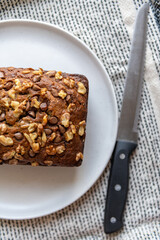 Fresh homemade banana bread with chocolate chips and walnuts on a white ceramic plate