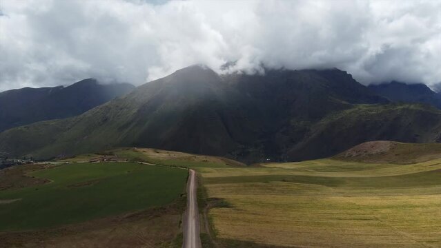 Camino entre campos y monta&ntilde;as con nubes