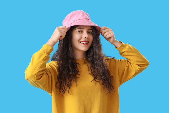 Teenage girl in pink bucket hat on blue background