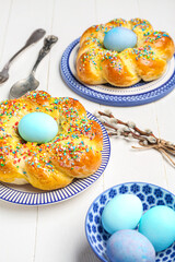 Table setting with tasty Italian Easter bread on white wooden background, closeup