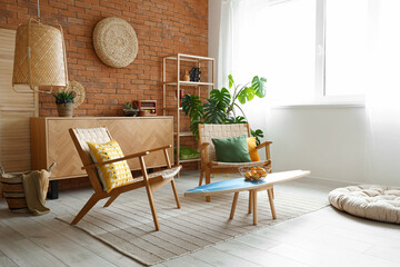 Cozy wooden armchairs with cushions and fruit basket on surfing board in interior of living room