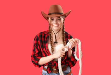 Fototapeta na wymiar Young cowgirl with lasso on red background