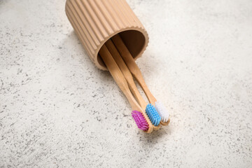 Holder with bamboo toothbrushes on grunge background