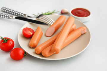 Plate of tasty sausages with tomatoes and ketchup on grey background