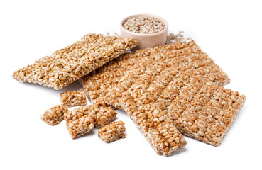 Bowl with sunflower seeds and tasty kozinaki on white background