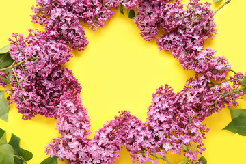 Frame made of beautiful blooming lilac flowers on yellow background
