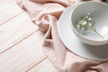 Bowl with beautiful gypsophila flowers on color wooden background, closeup