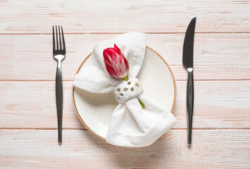Beautiful table setting and tulip flower on color wooden background