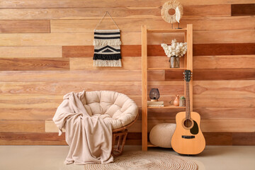 Fototapeta na wymiar Interior of living room with armchair, shelving unit and guitar