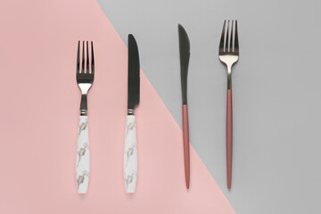 Silver cutlery on color background