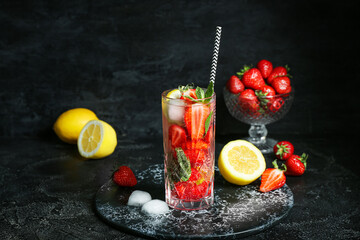 Fototapeta Glass of fresh mojito and bowl with strawberry on grunge black background obraz