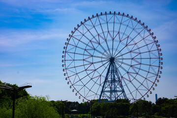 Fototapeta premium A ferris wheel at the park behind the blue sky