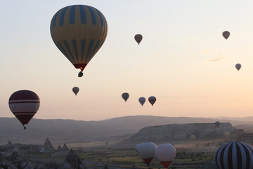 Colorful hot air balloons floating in air at bright sunrise