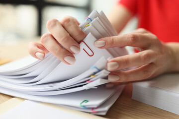 Female secretary looks through fastened papers in office