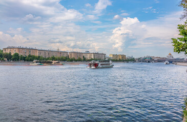 Fototapeta na wymiar Cruise ship sails on the Moscow river in Moscow city center, popular place for walking.