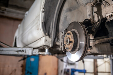 Disc brake of the vehicle for repair, in process of new tire replacement. Car brake repairing in...