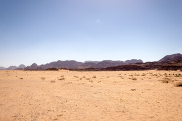Fototapeta na wymiar Scenic vista of Wadi Rum (Valley of the Moon) desert in southern Jordan, showcasing its striking red sand dunes, magnificent sandstone formations, and rugged granite rock landscapes. 