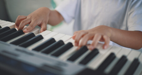 Fototapeta na wymiar Cute boy enjoy to learning playing piano at home