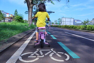 little girl is riding her bicycle