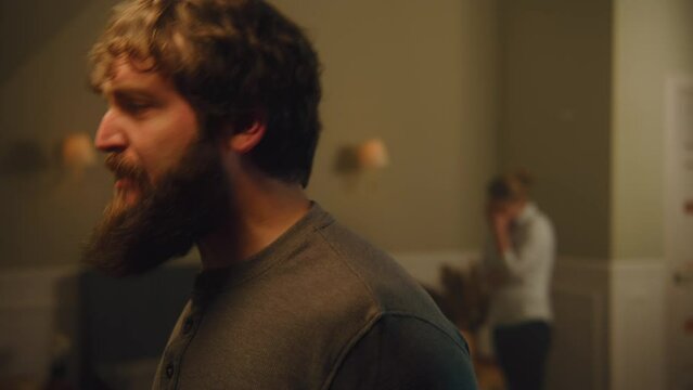 Irritated, angry elderly and adult man hit the wall with hands, yell at each other through thin walls. Neighbours quarrel. Apartment without sound insulation. Concept of neighbourhood and lifestyle.