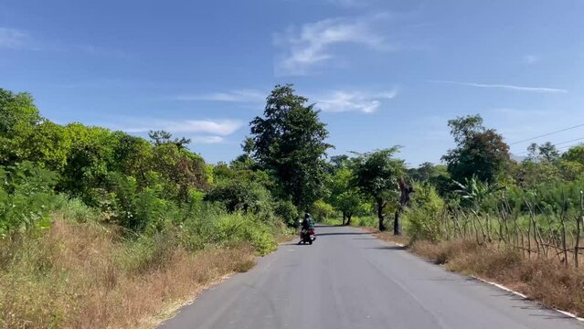 Driving On Paved Road With Person Riding A Motorcycle Near Cotigao Sanctuary In Netravali, Goa India. POV