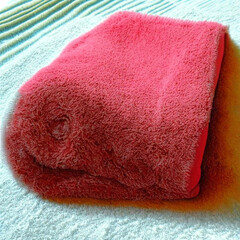 pink cotton towel folded on the bed