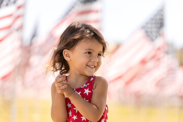 Happy toddler girl celebrating the Fourth of July in the park, childhood memories and Independence Day concept