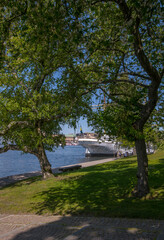 Stern of old steel hostel sailing ship Chapman green trees and a pier, a sunny summer day in Stockholm 