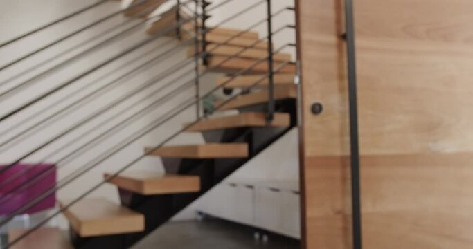 Wooden and metal floating staircase and wooden door in modern home interior, slow motion